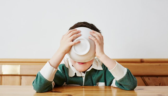 boy drinking milk cereal bowl