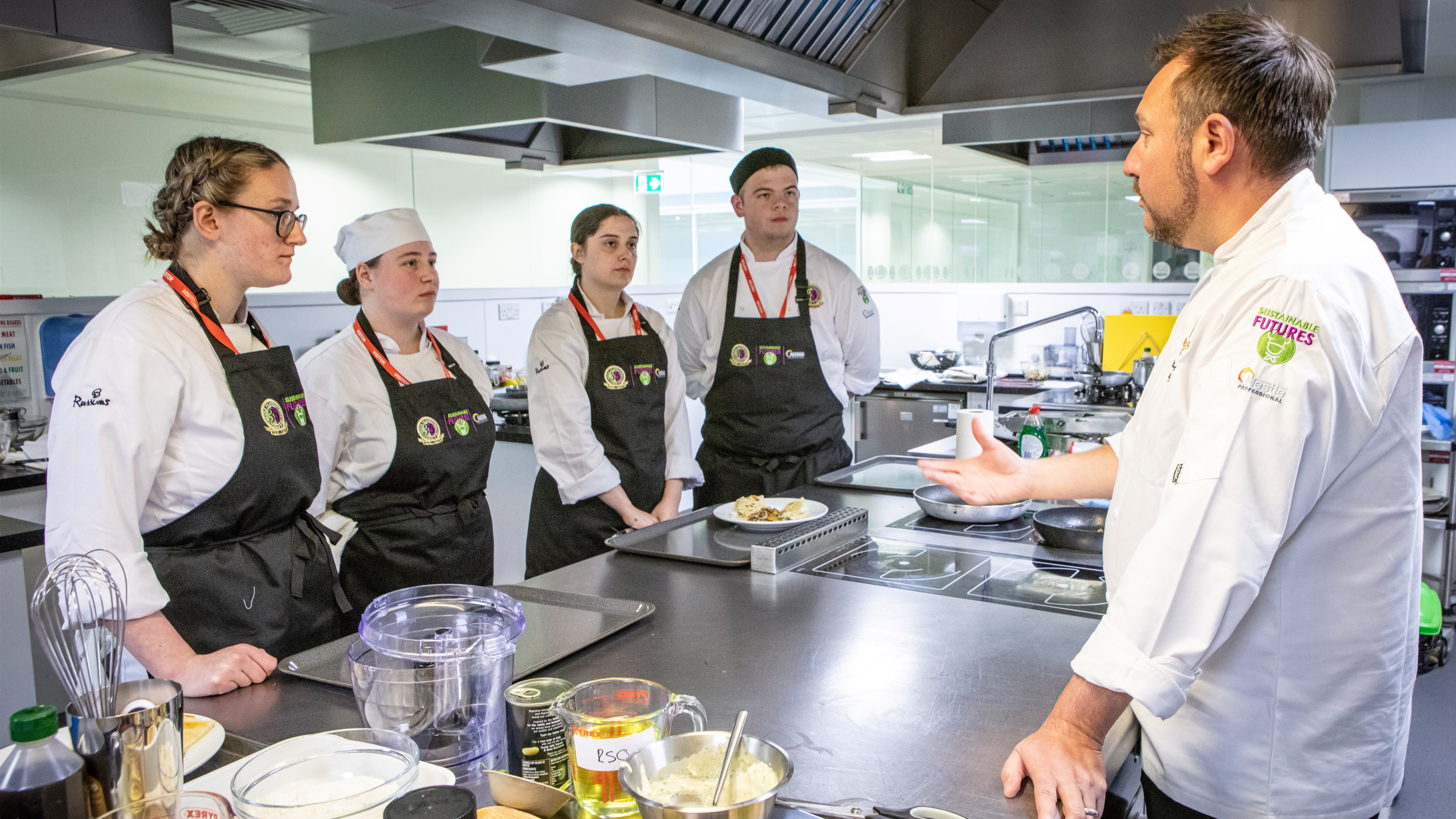 Chefs gathered around a table in a kitchen
