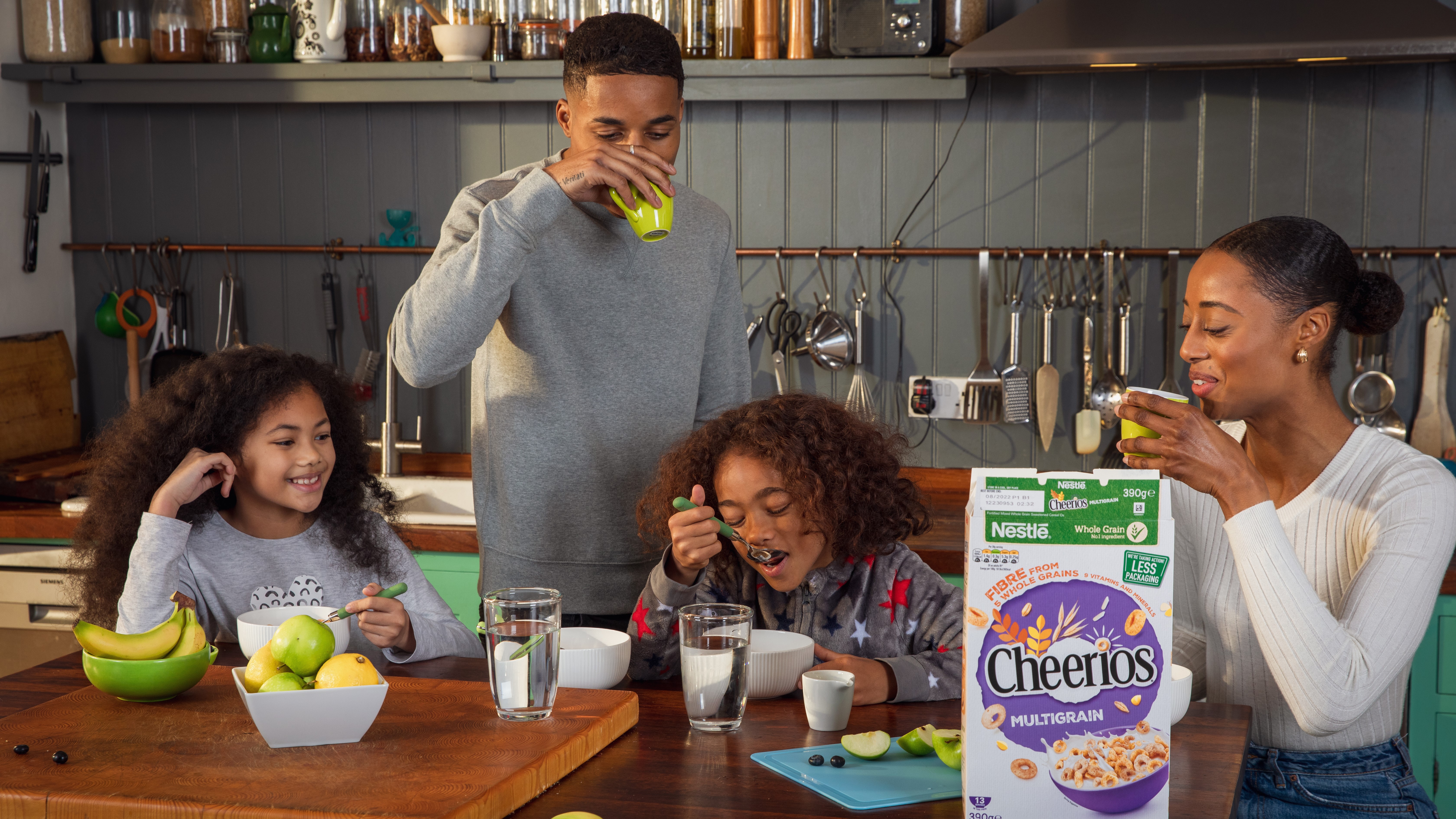 Two parents and two children gathered around the table eating Cheerios cereal