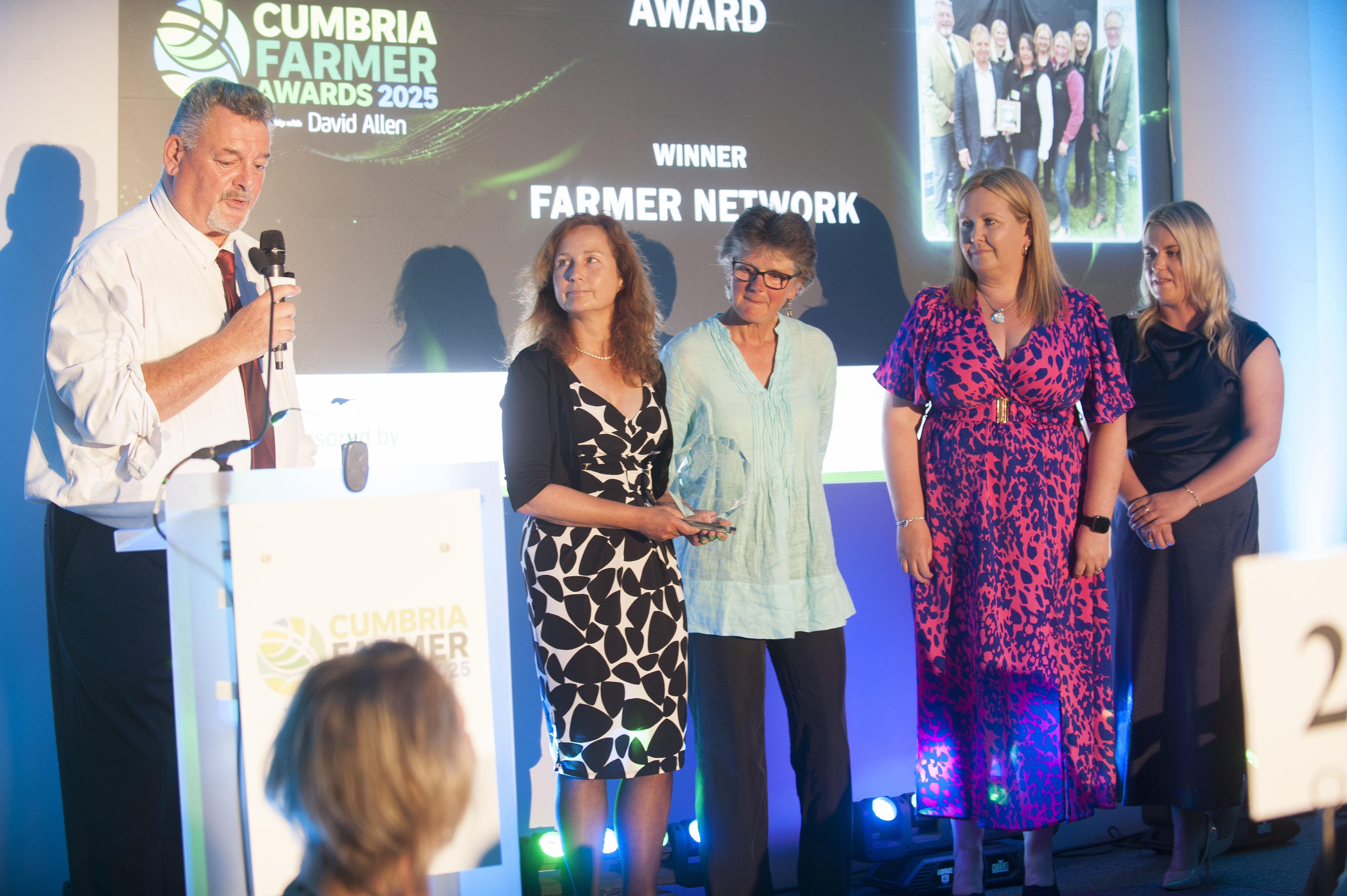 A group of people standing on stage being presented with an award