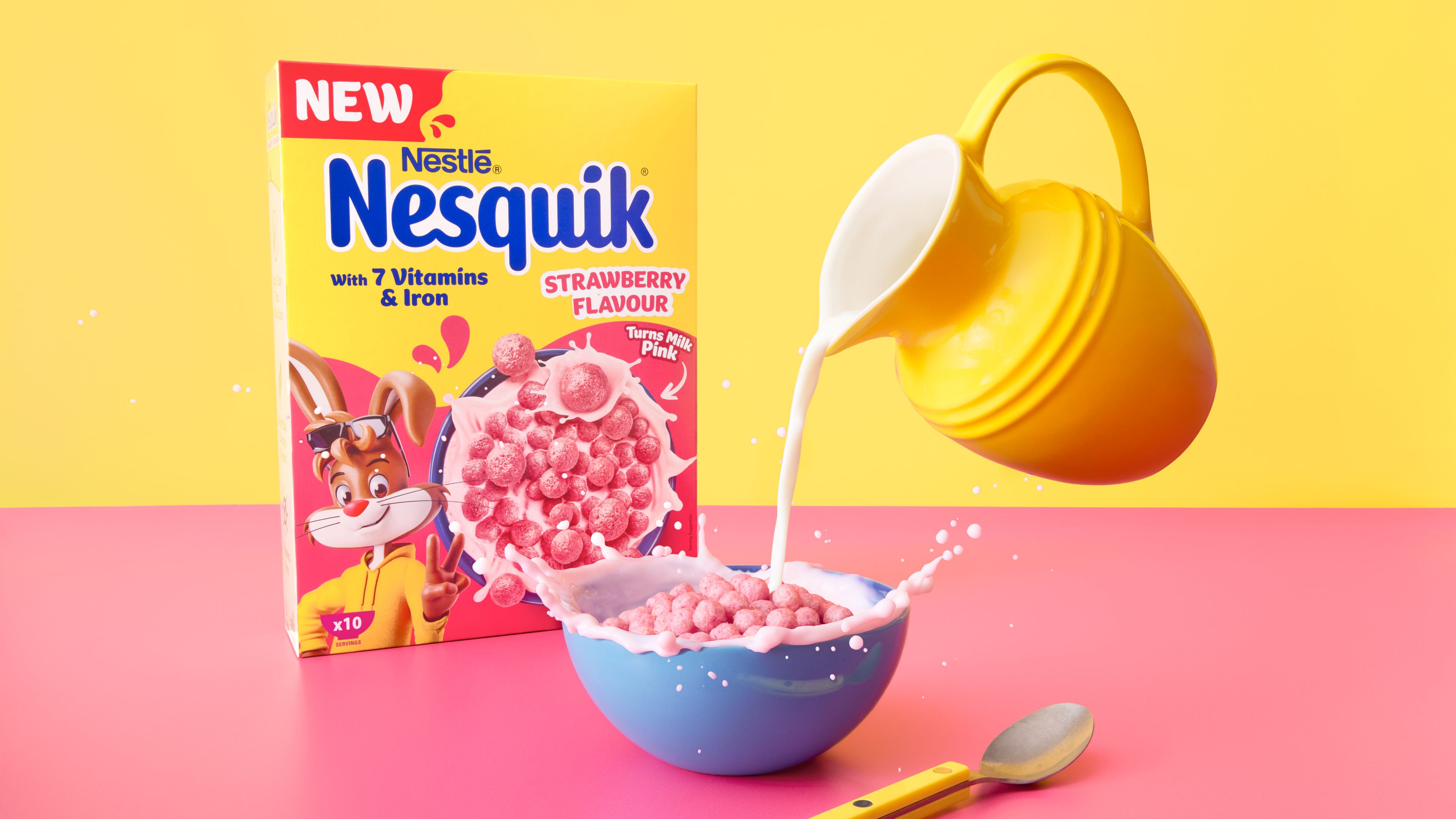 A jar on milk being poured into a bowl of Nesquik strawberry flavour cereal