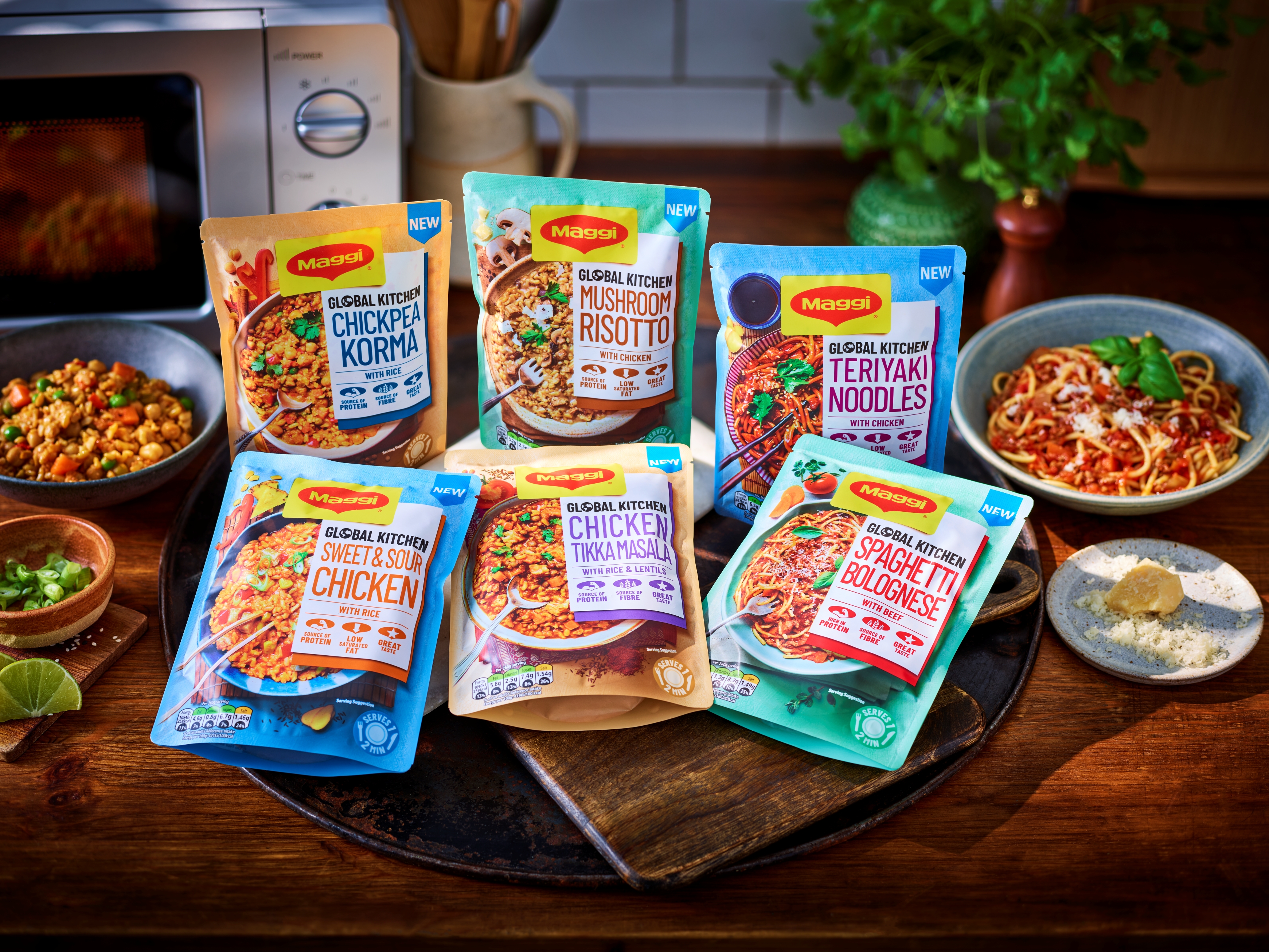 Landscape shot of kitchen countertop with six ready-meal pouches arranged together next to bowls of food.