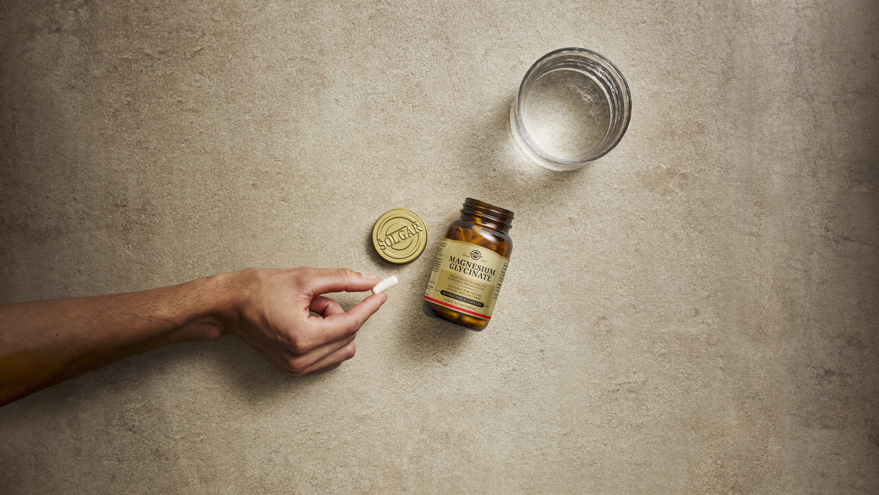 Hand grabbing pill from bottle