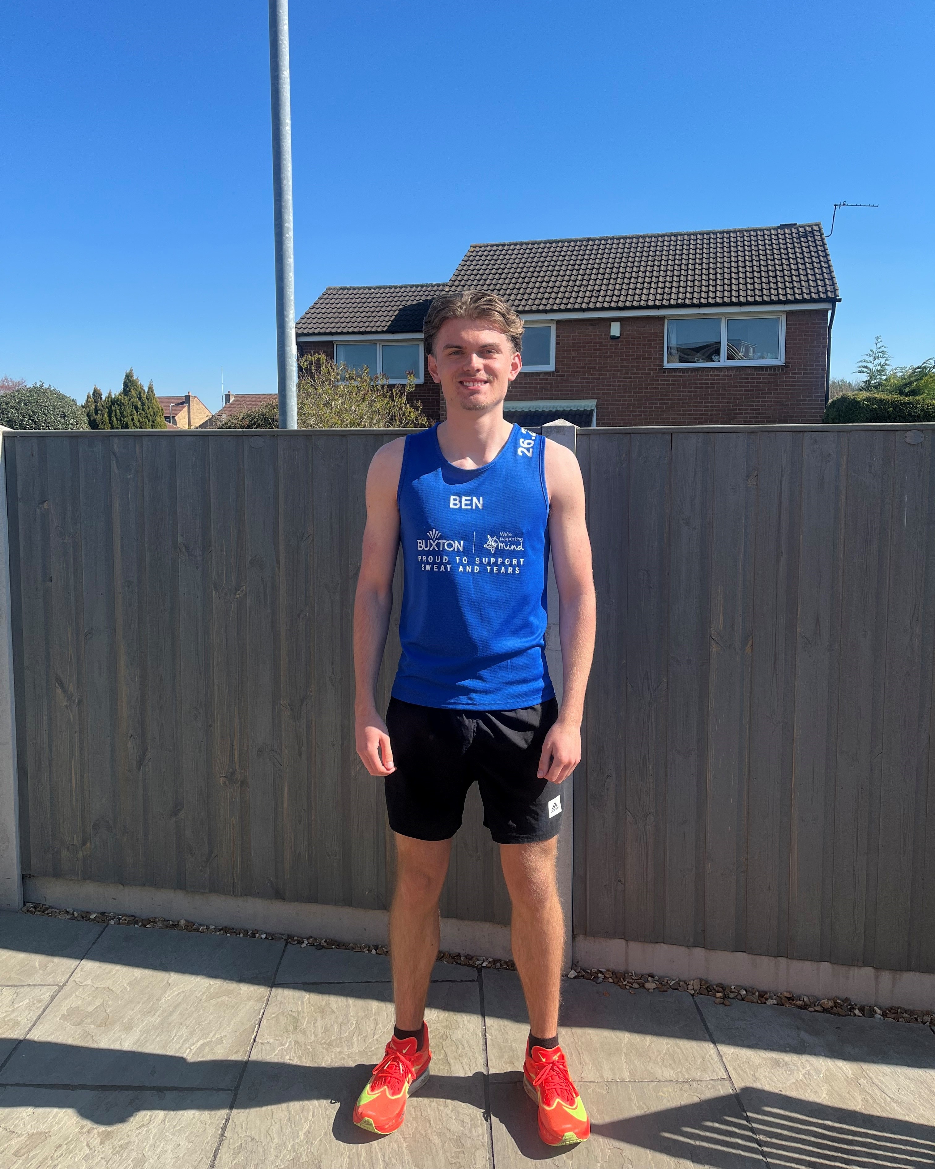 Young man in athletic clothing standing outside.