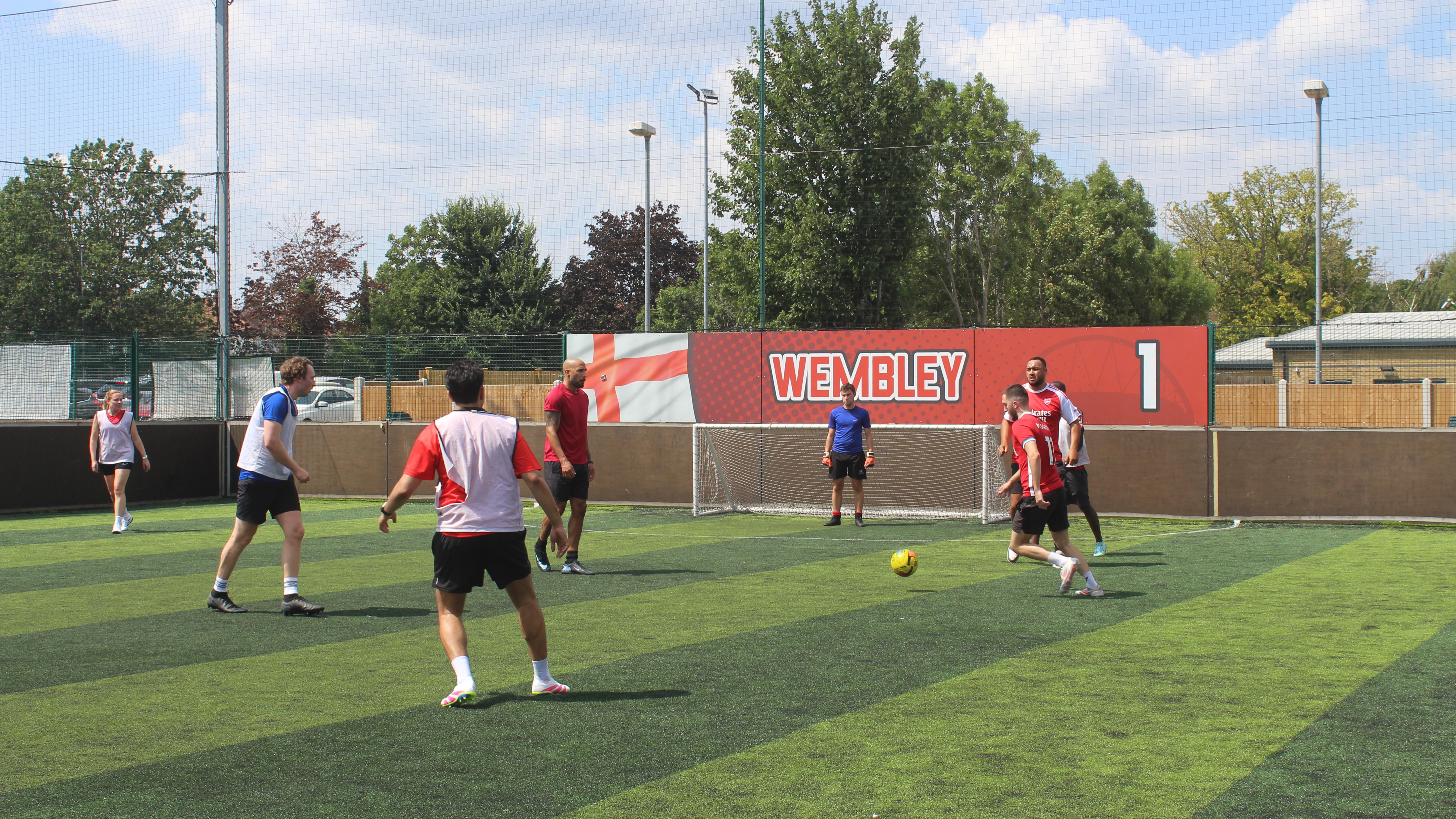Group of colleagues in fitness clothes on a football match, playing the game.