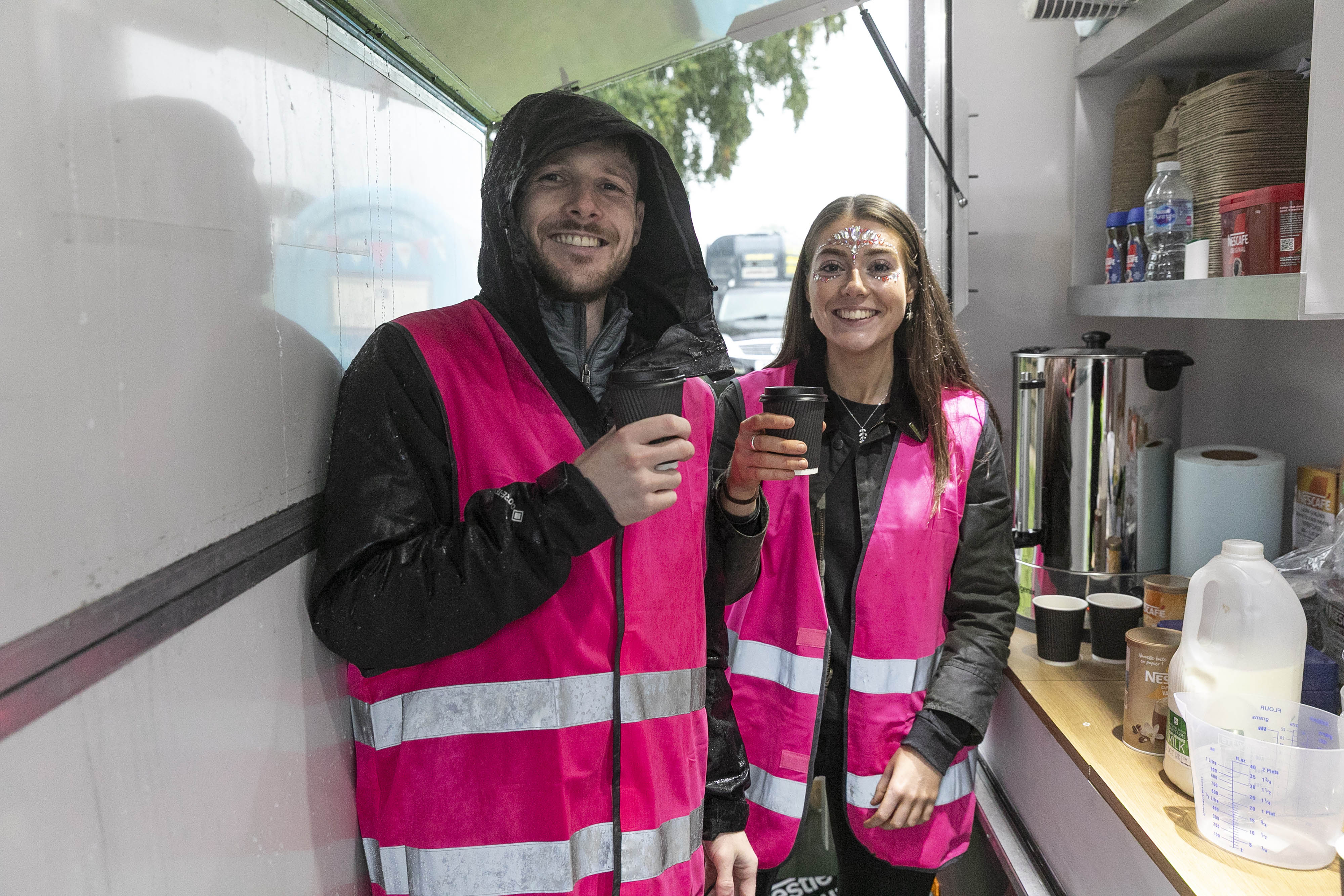two individuals with coffee cups smiling