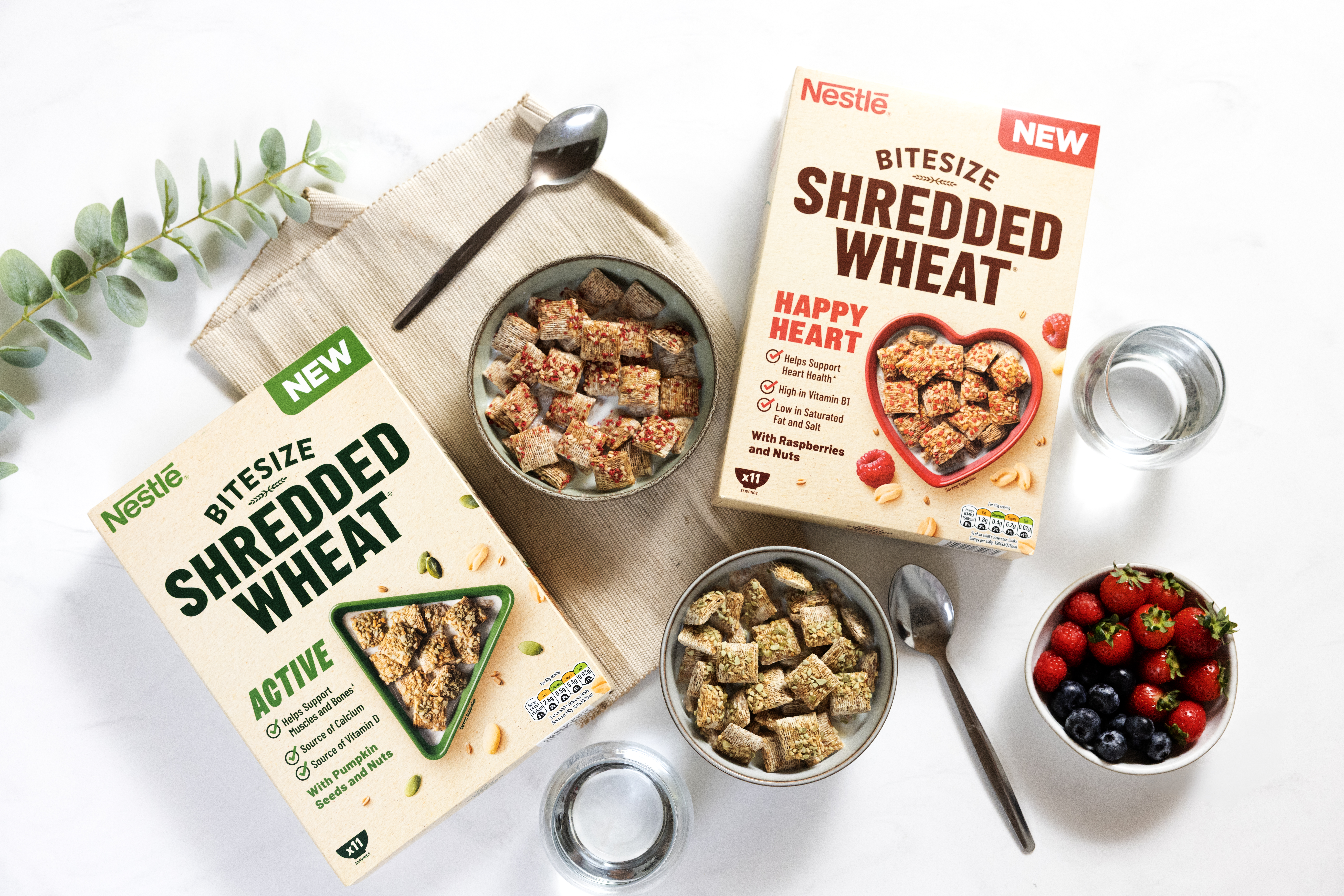 A breakfast table featuring two boxes of Shredded Wheat and bowls filled with the cereal and milk.