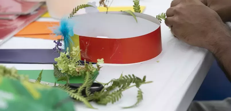 An image of a child craftmaking on a table with a white tablecloth over it.