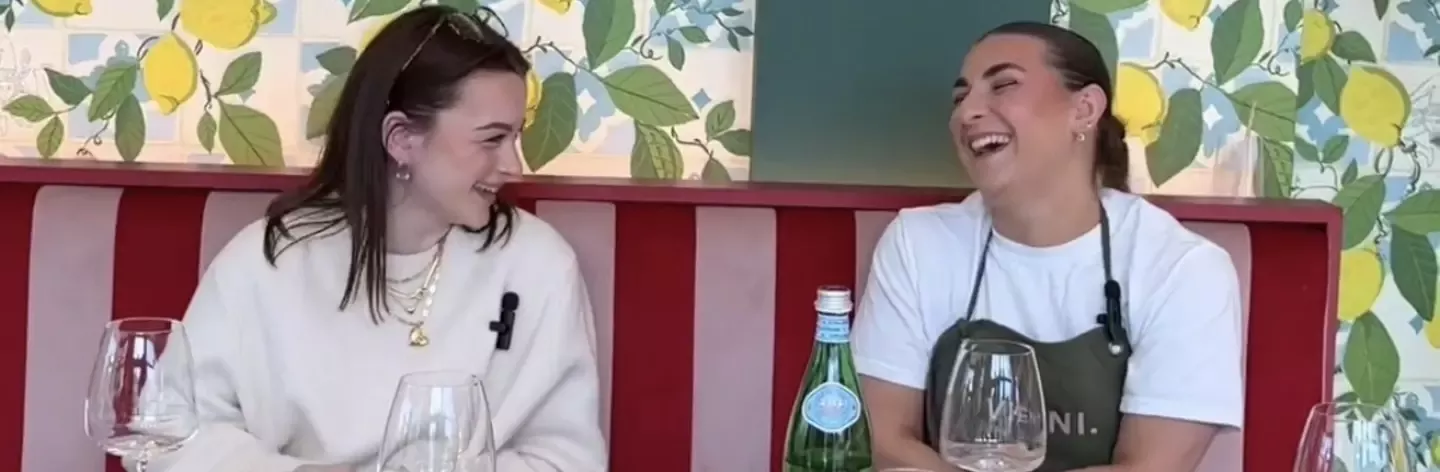 Two women sat at a table laughing