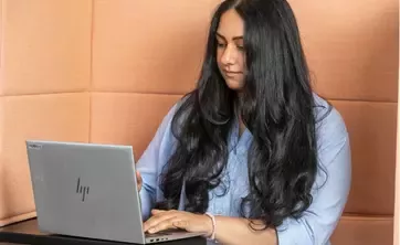 Person working on a laptop in a modern office environment.