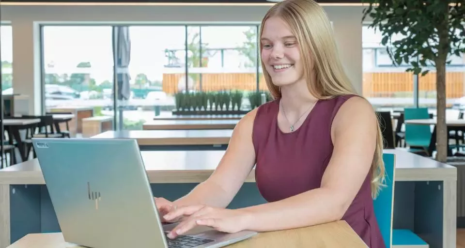 Person working on a laptop in a modern office environment.