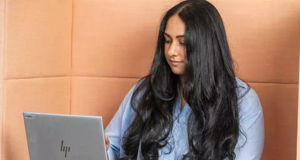 Person working on a laptop in a modern office environment.