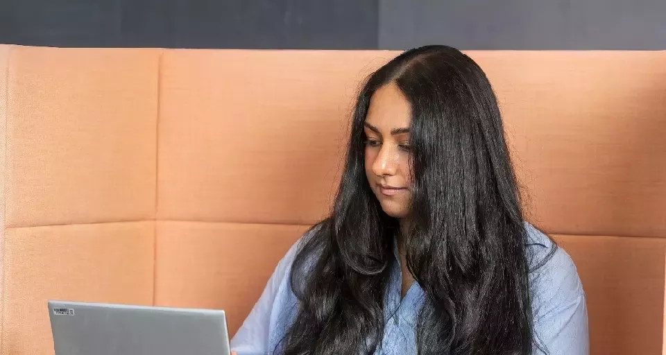 Person working on a laptop in a modern office environment.