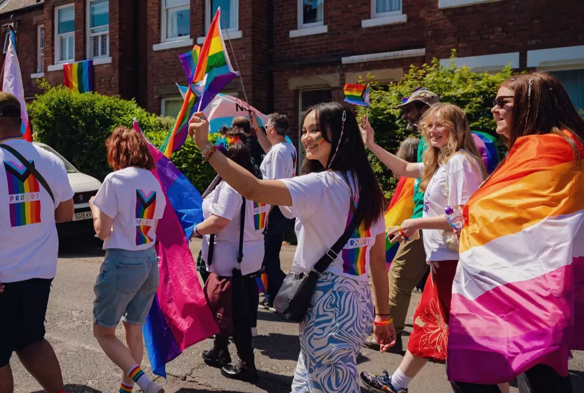 Woman holding Pride flag at a Pride march. 