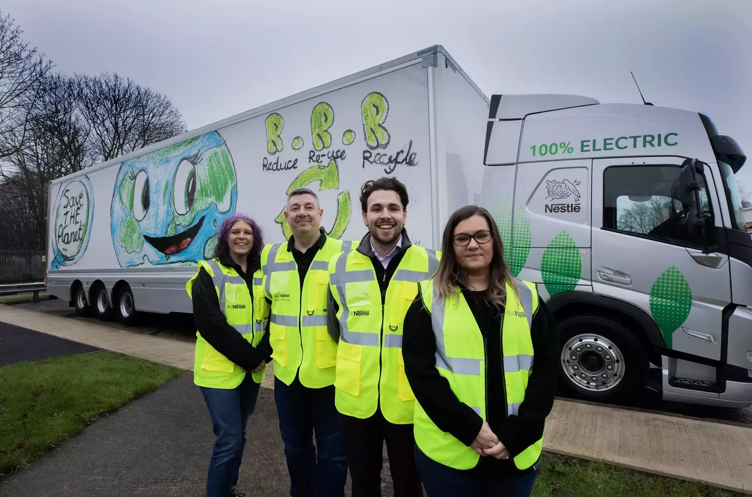 Four people wearing high-vis clothing standing in front of an electric truck. 