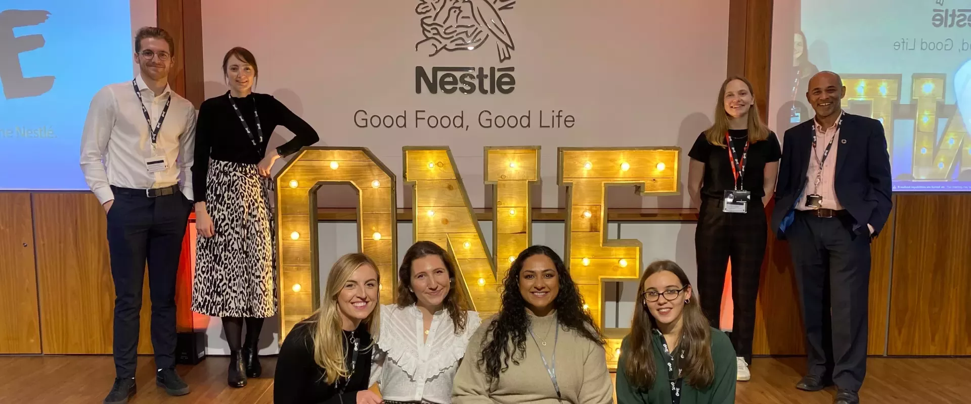 group in front of a sign saying 'one'