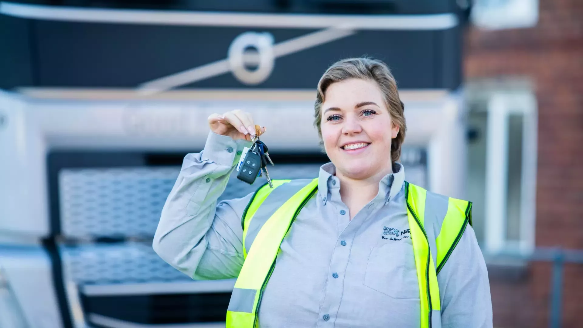 Nestlé apprentice Lucy holds up keys in front of a lorry