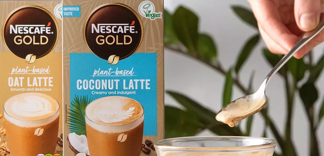 Nescafé Gold Oat and Coconut Latte packs next to one another behind a teaspoon with coffee on it