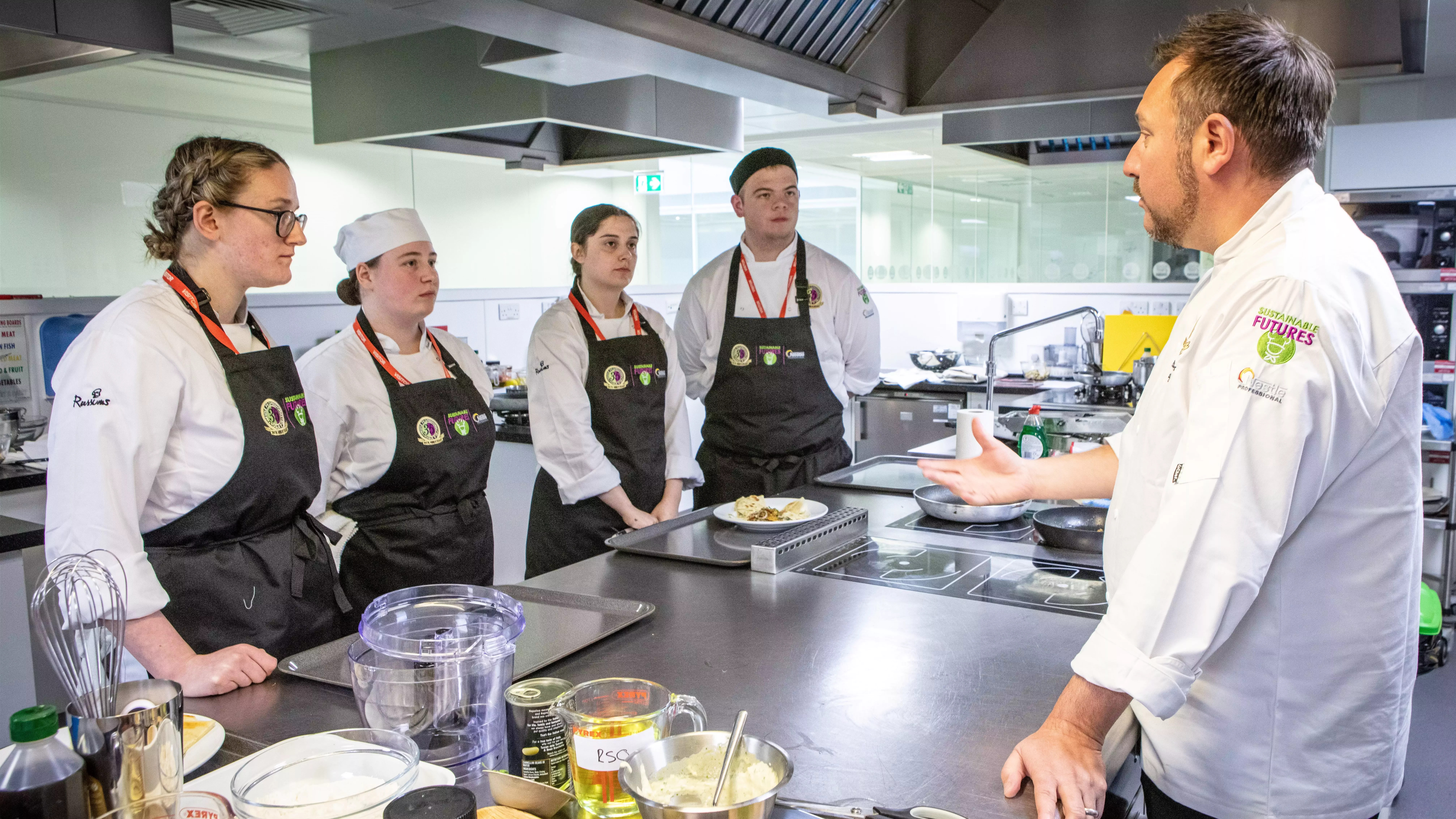 Chefs gathered around a table in a kitchen