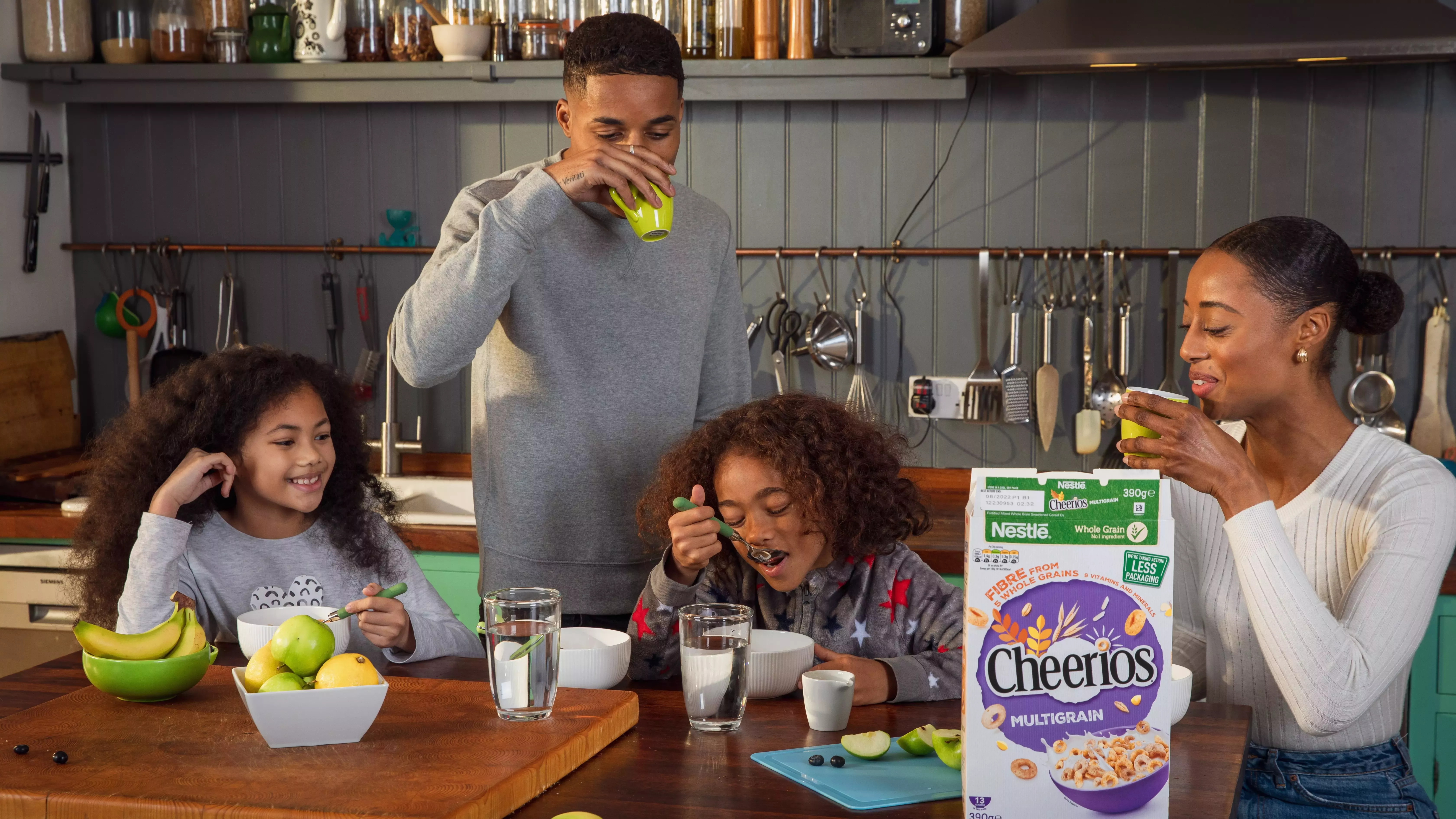 Two parents and two children gathered around the table eating Cheerios cereal