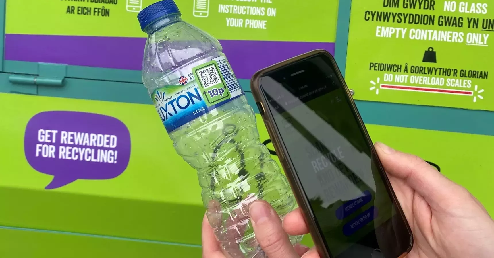 Hand holds mobile phone to scan the side of a Buxton bottle