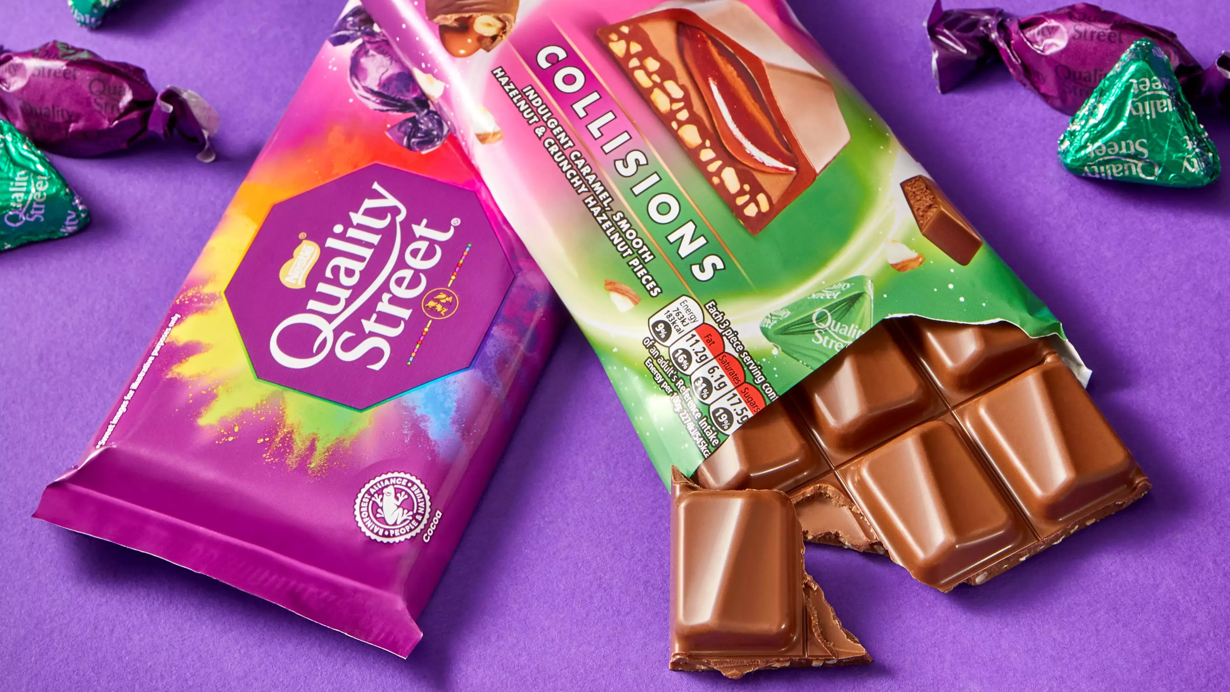 Two bars of Quality Street chocolate, with one packet open displaying the chocolate, on a purple background.