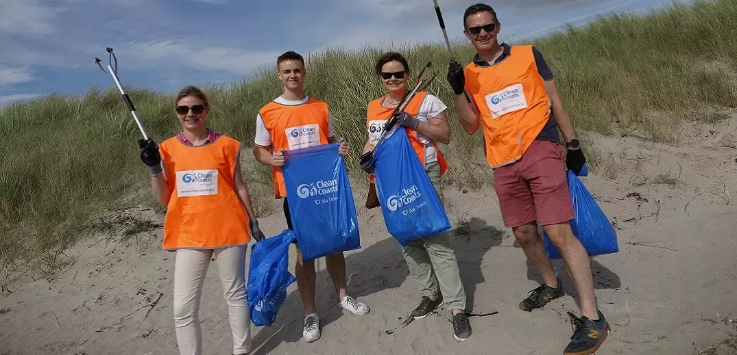 four people at beach clean