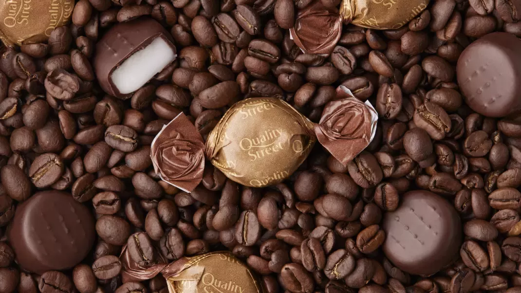 Coffee Creme Quality Street sweet on a bed of coffee beans