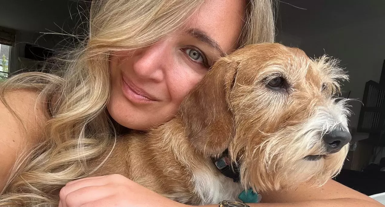 A woman with blonde hair hugging a dog called Luna, who also has a blonde hair coat.