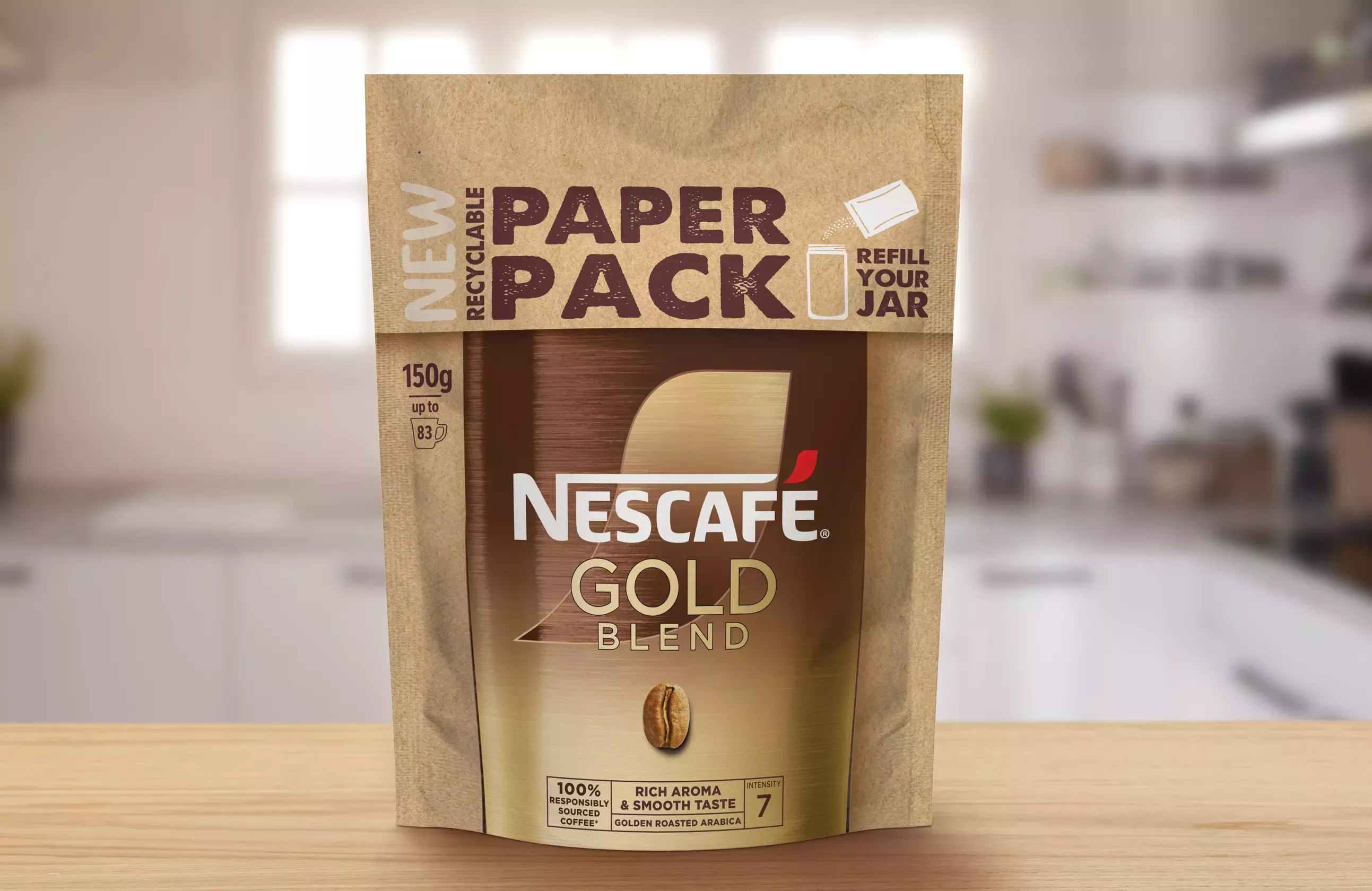 A paper pack of Nescafé Gold Blend coffee, on a light brown wooden kitchen surface.
