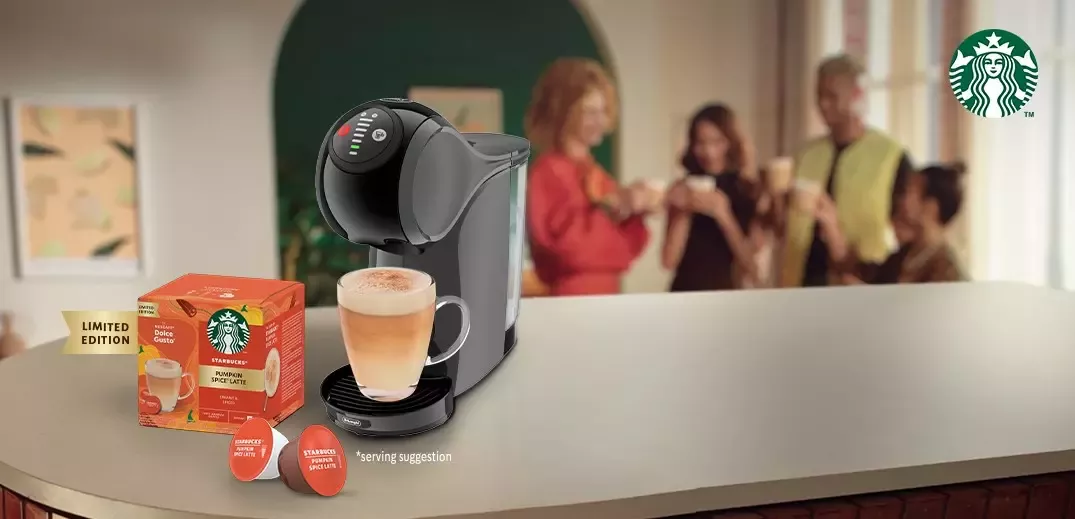 A landscape image of a Starbucks Pumpkin Spice Latte poured from a black Nescafé Dulce Gusto machine.