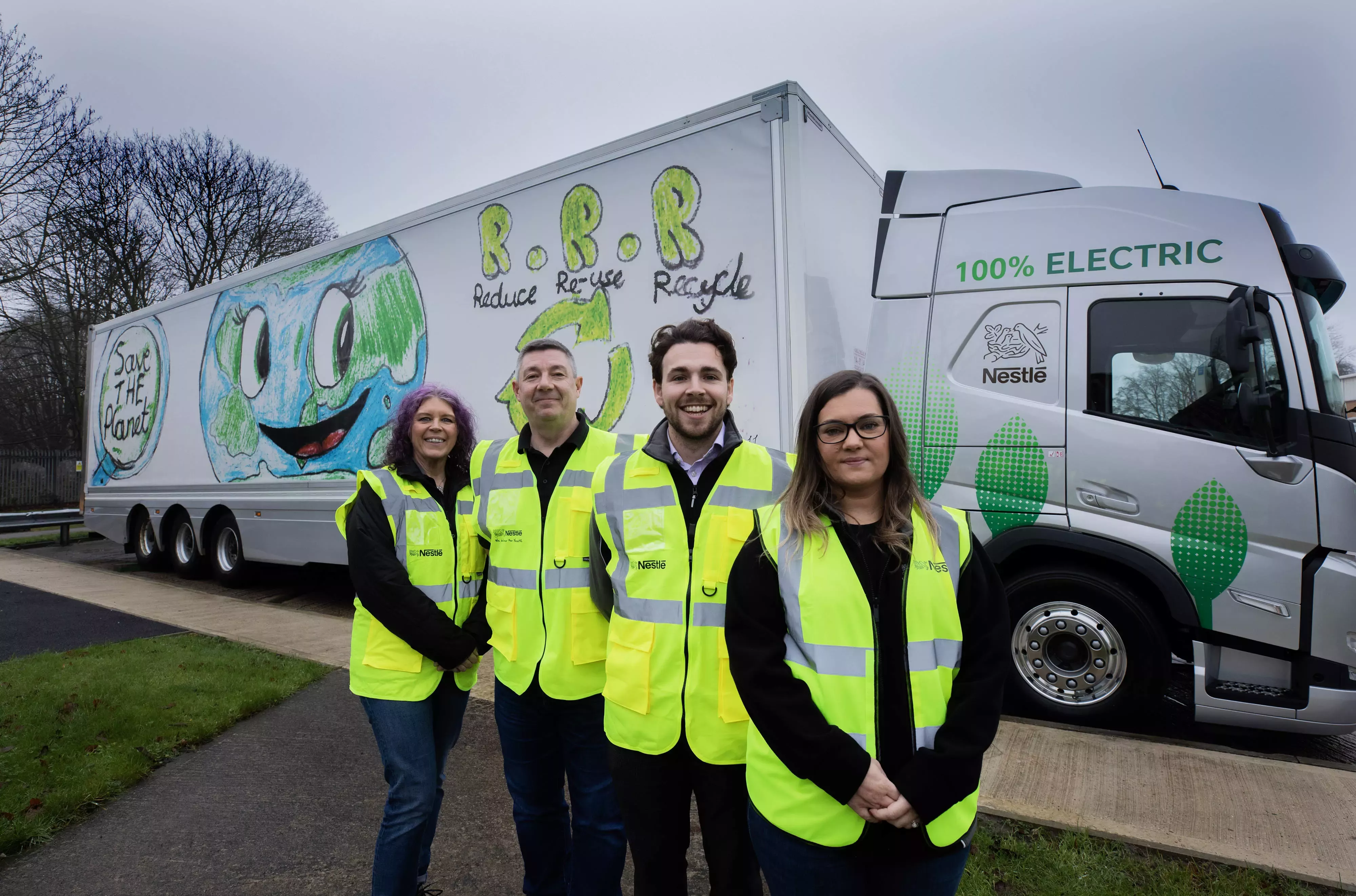 Four people wearing high-vis clothing standing in front of an electric truck.