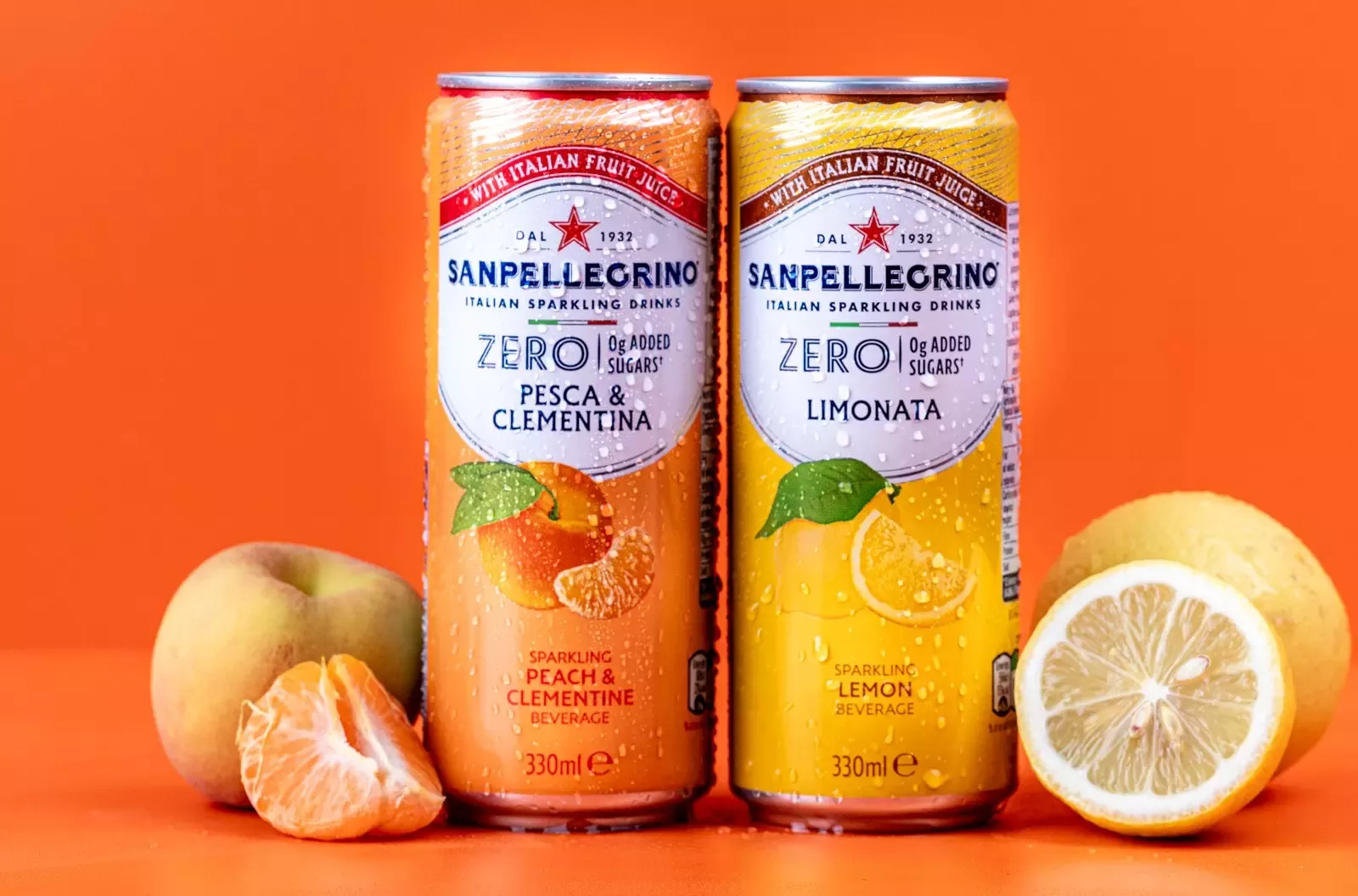 Sanpellegrino Zero Added Sugar Limonata and Pesca and Clementina cans next to each other in front of a orange backdrop
