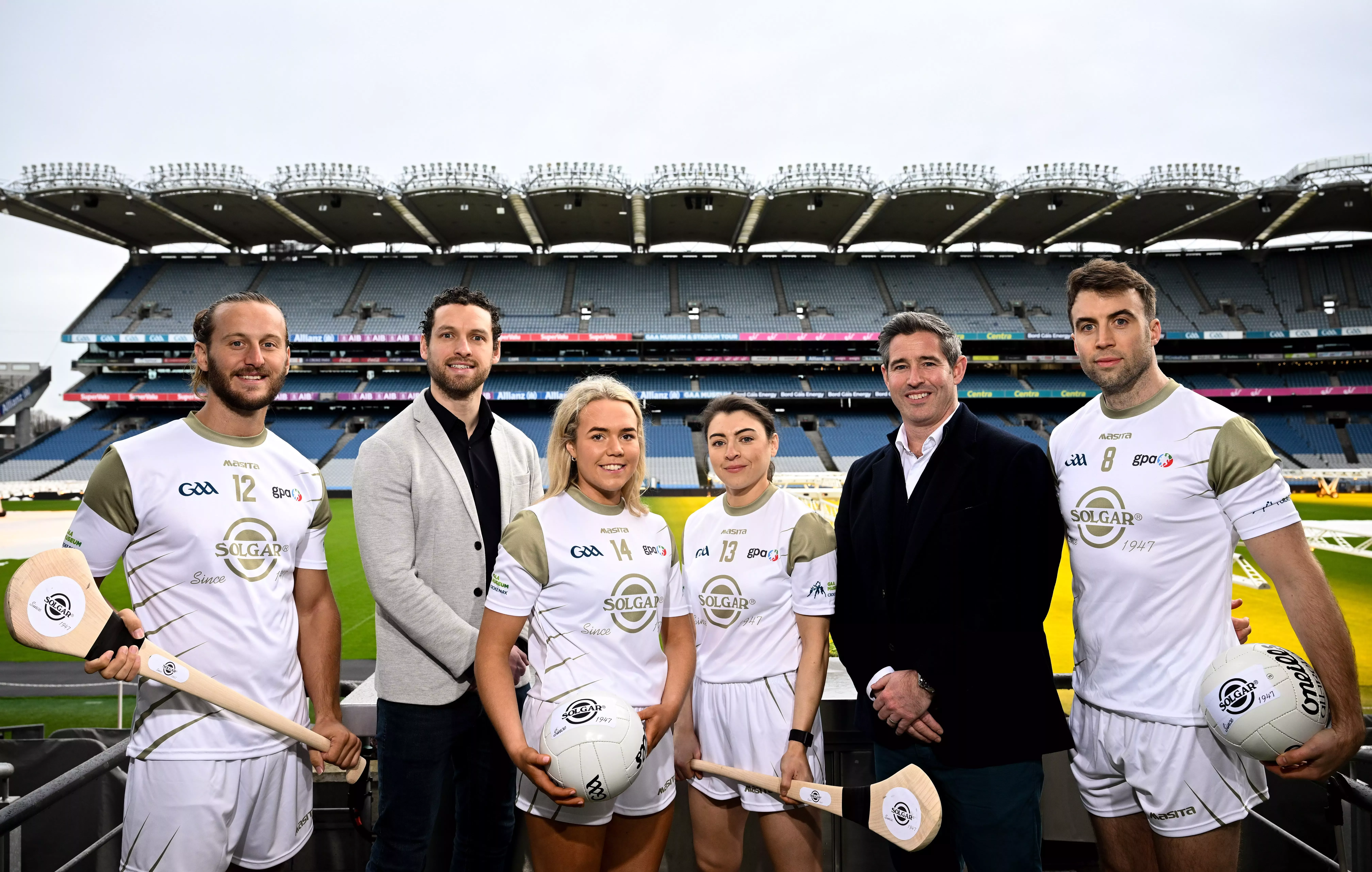 Six people standing in a sports stadium.