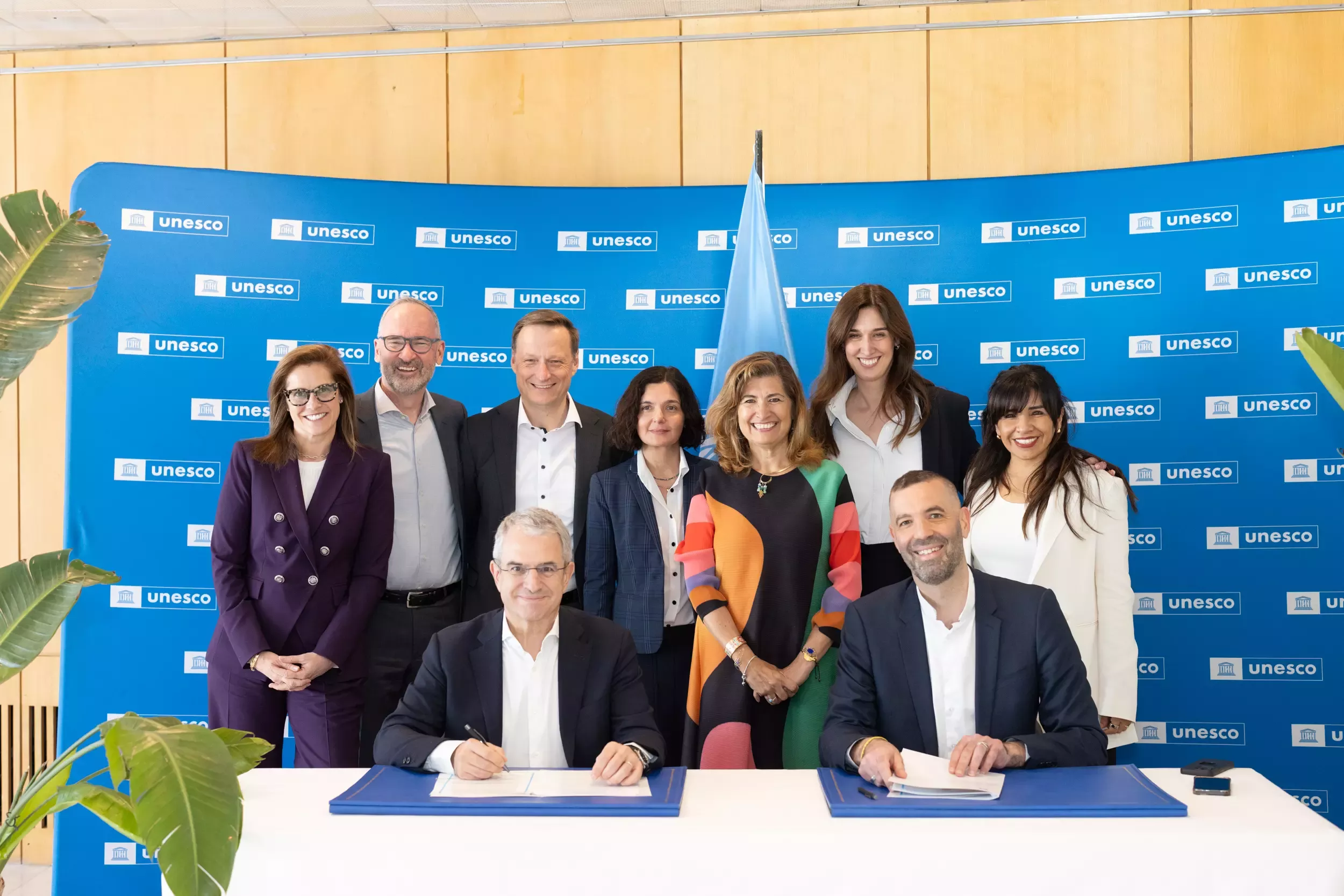 A group of men and women standing behind a table smiling at the camera