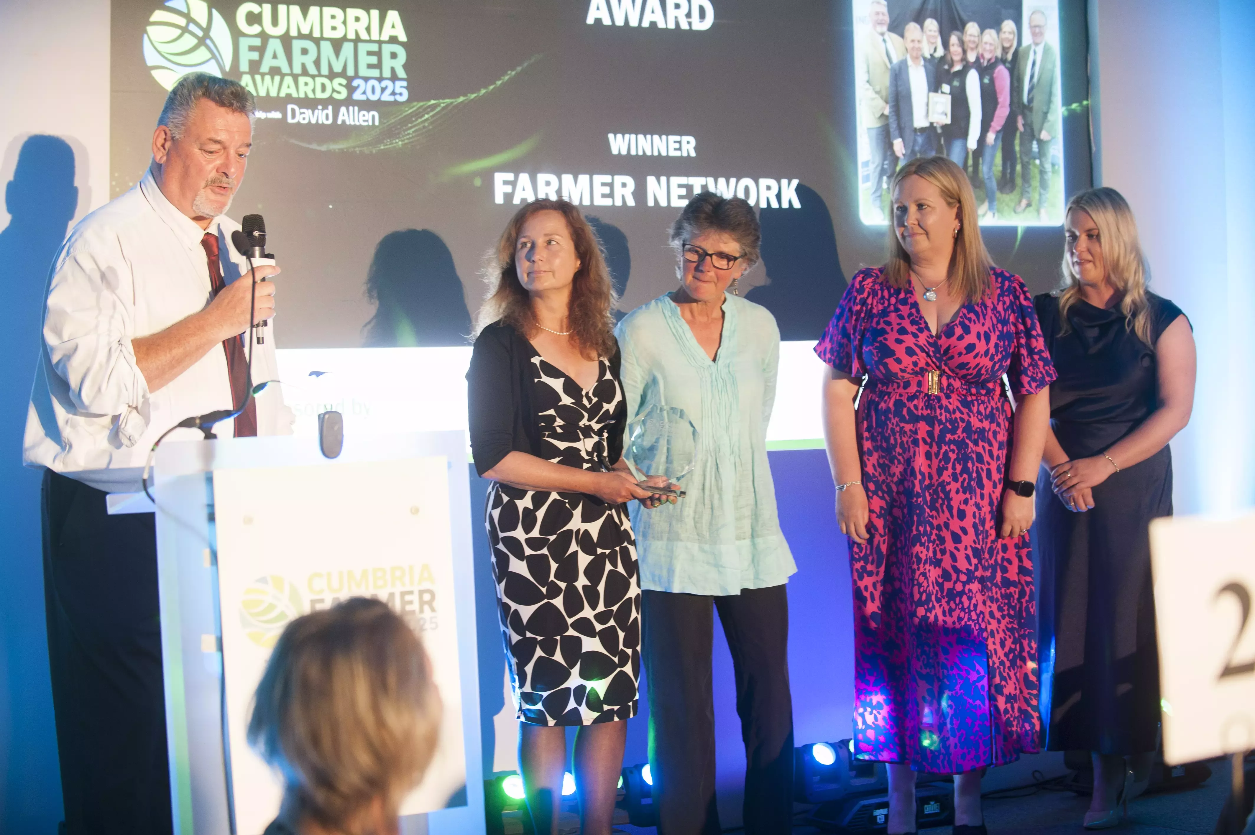A group of people standing on stage being presented with an award