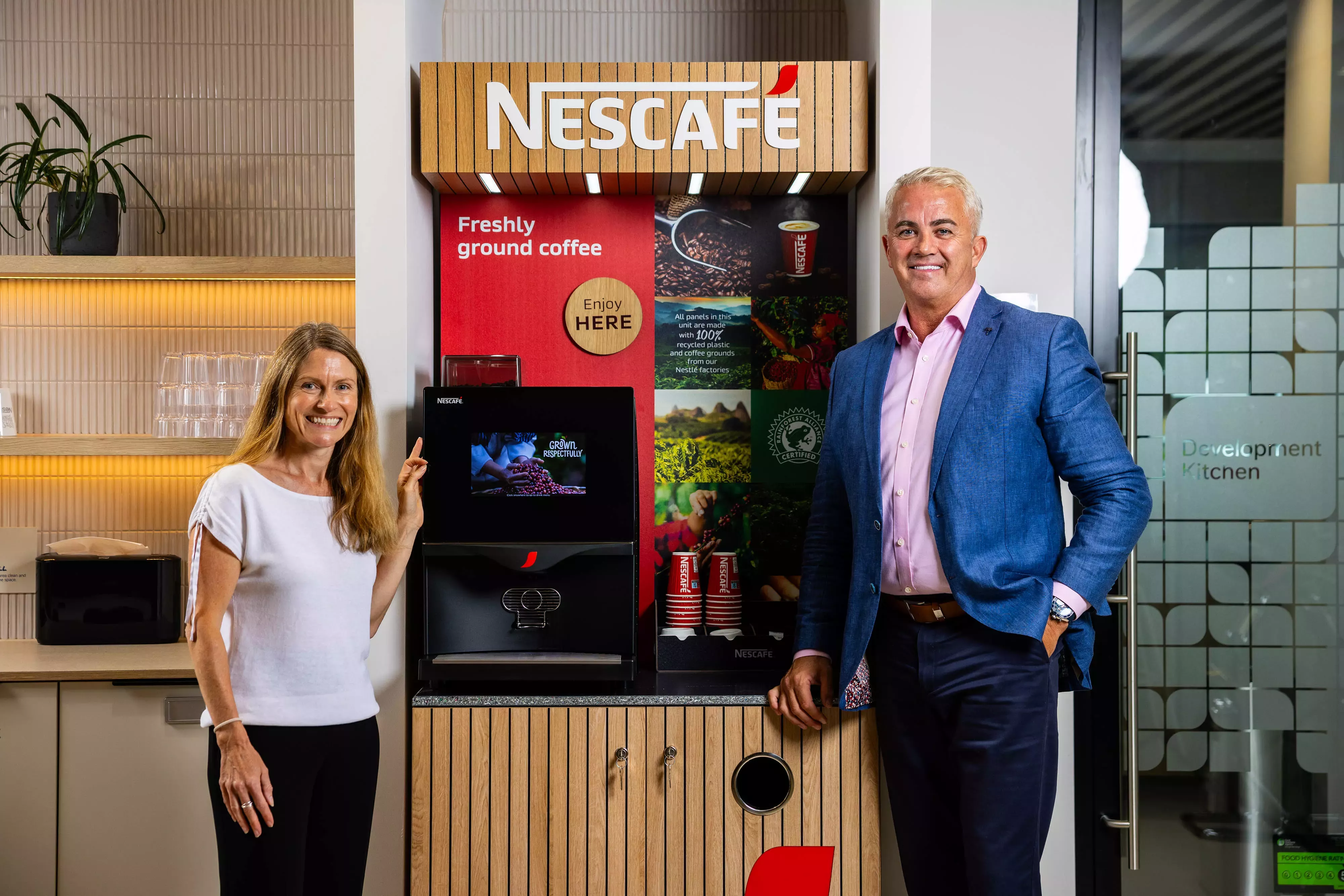 Stuart and Julia standing next to the sustainable Nescafé self-serve unit