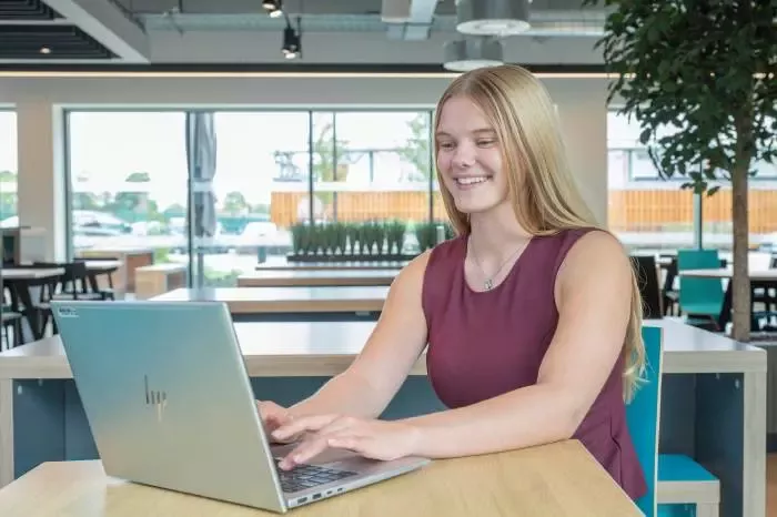 Person working on a laptop in a modern office environment.
