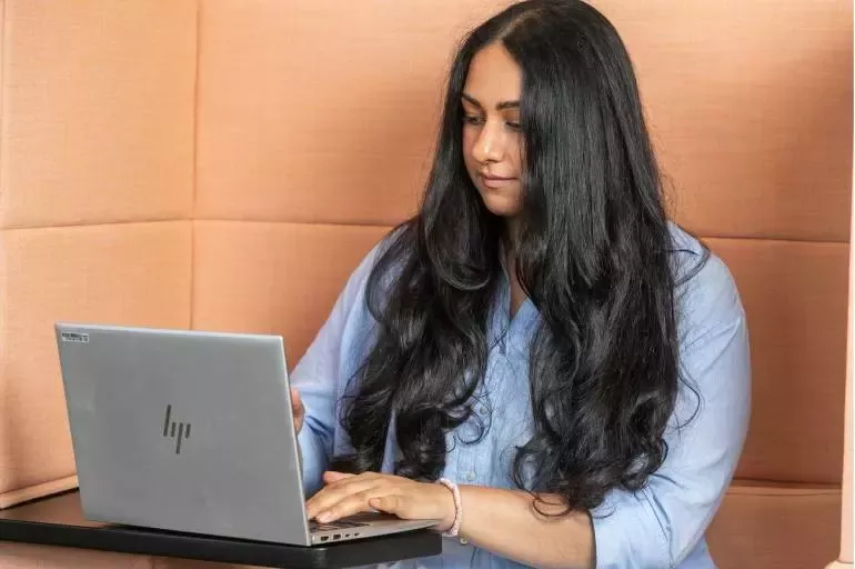 Person working on a laptop in a modern office environment.