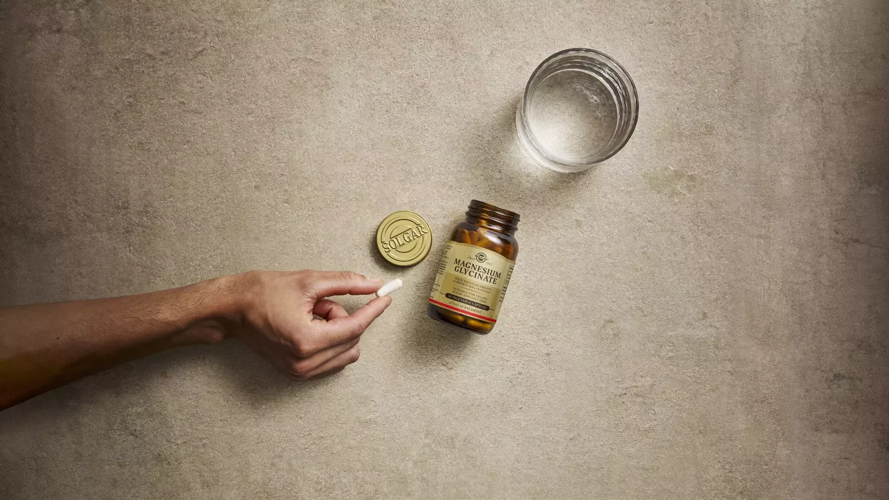 Hand grabbing pill from bottle