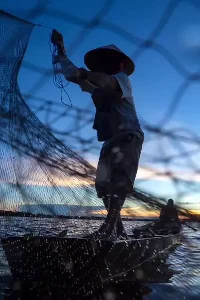 fisherman with net sunset